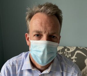 listening to sad person wearing a mask