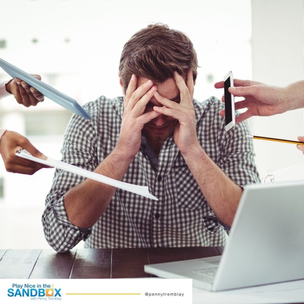 image of man at a desk with his head in his hands and a laptop and several people handing him work to do showing mistakes leaders make