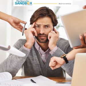 image of a boss at a desk with several workers handing him files to show mistakes leaders should avoid