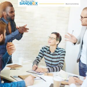 image of 2 men standing and a woman sitting at a table having a friendly debate