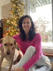 image of Penny Tremblay and her dog Lira sitting in front of the Christmas tree to express gratitude