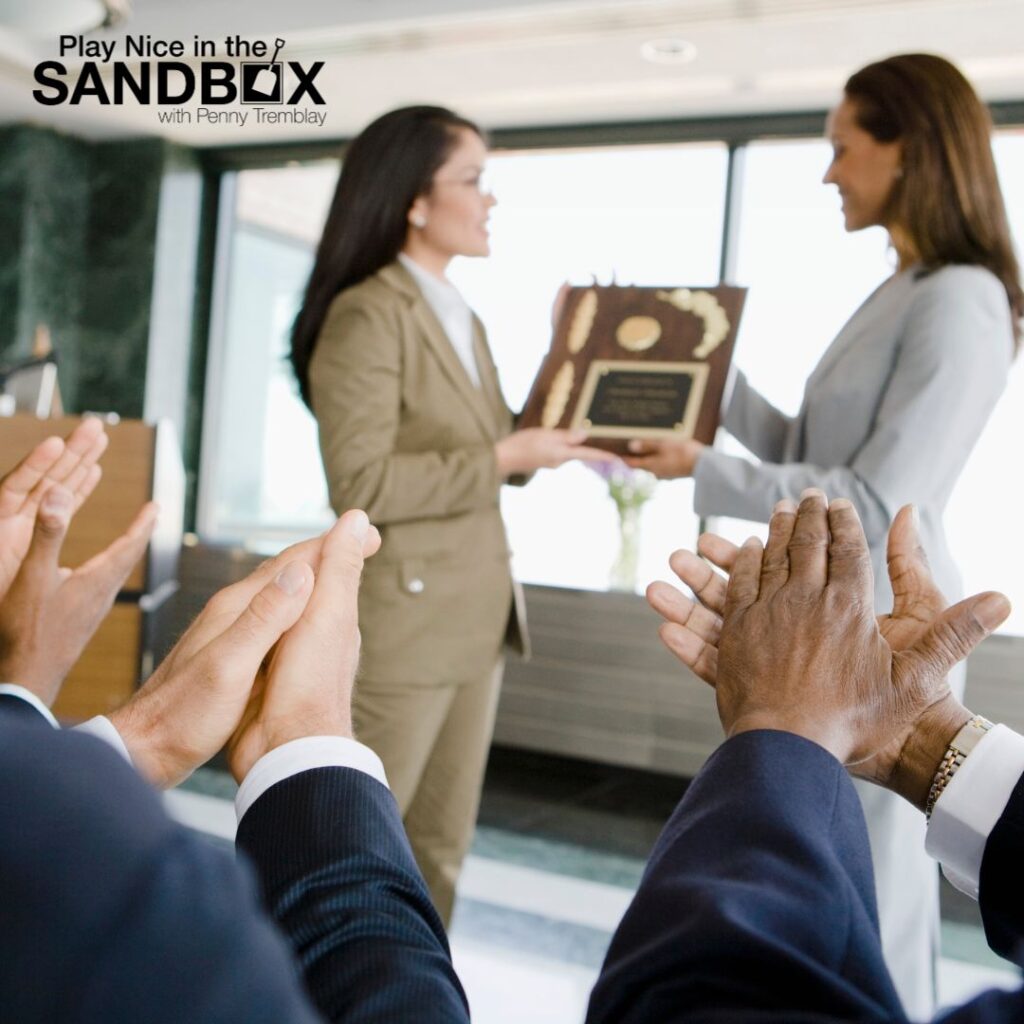 image of one colleague presenting another with a plaque and other colleagues clapping in the audience to show how to Keep Your Employees Engaged: Motivating a Diverse Workforce in Changing Times
