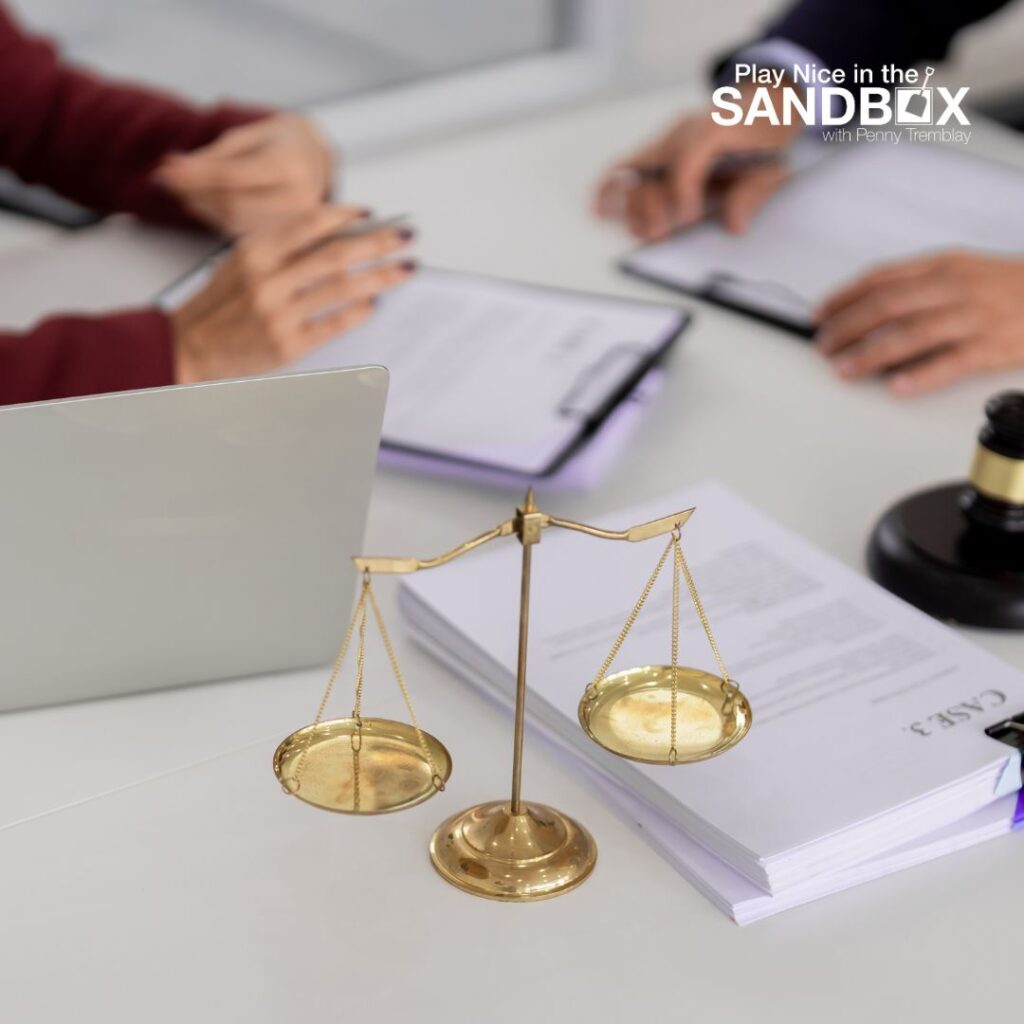 image of a set of scales on a desk with a note pad and laptop where the hands of 2 coworkers are on the desk to show workplace fairness