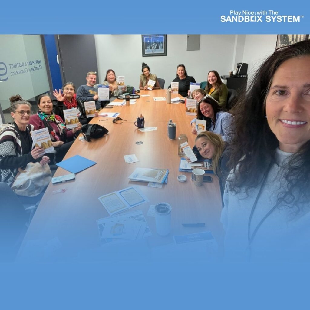 image of Penny Tremblay with a group of clients behind her at a training session table to display Resetting Team Culture for the New Year- How Leaders Set the Emotional Tone