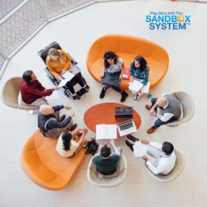 image of several coworkers sitting in chairs together in a circle around a table to show The Real Reason Teams Struggle with Accountability (and How to Fix It)