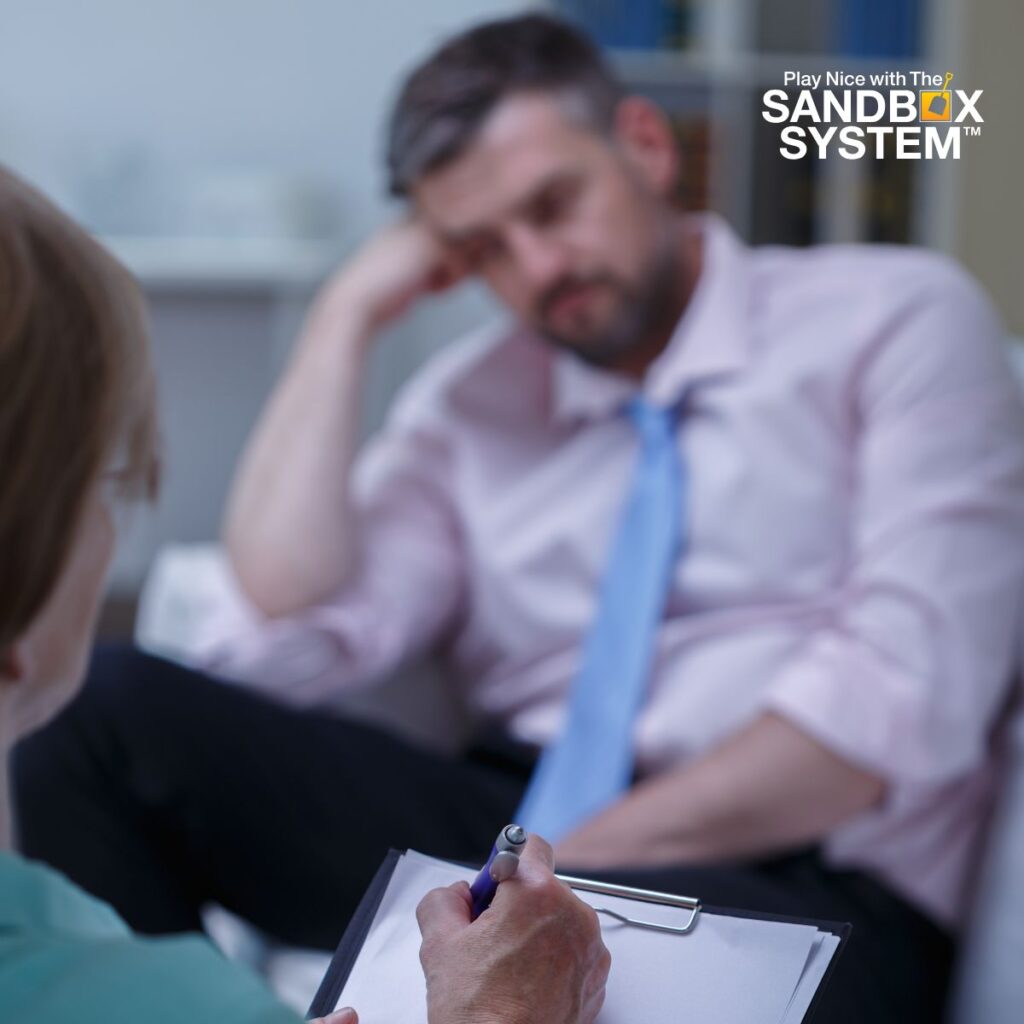 image looking over the shoulder of a supervisor taking notes while a coworker sits looking forlorn to show Signs That Your Workplace is Psychologically Unsafe